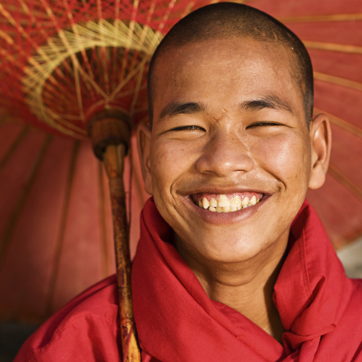 Man smiling under a tropical umbrella